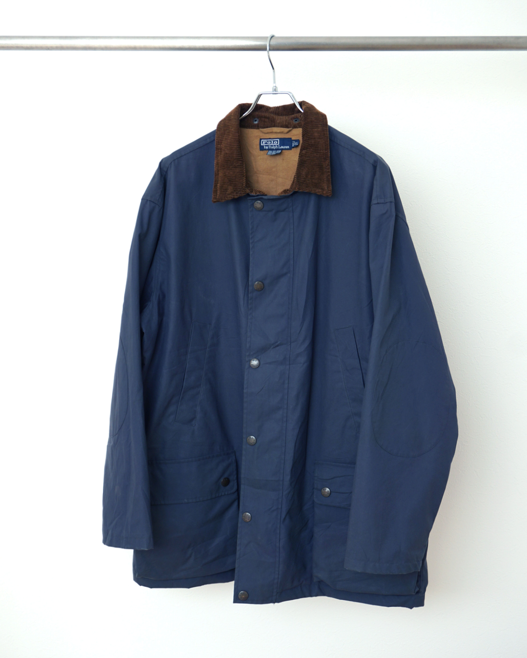 CALCÈLで販売されるPolo by Ralph Laurenのネイビーのユーティリティジャケット。コーデュロイ襟と肘当てが特徴的な綿100%のヴィンテージアウター