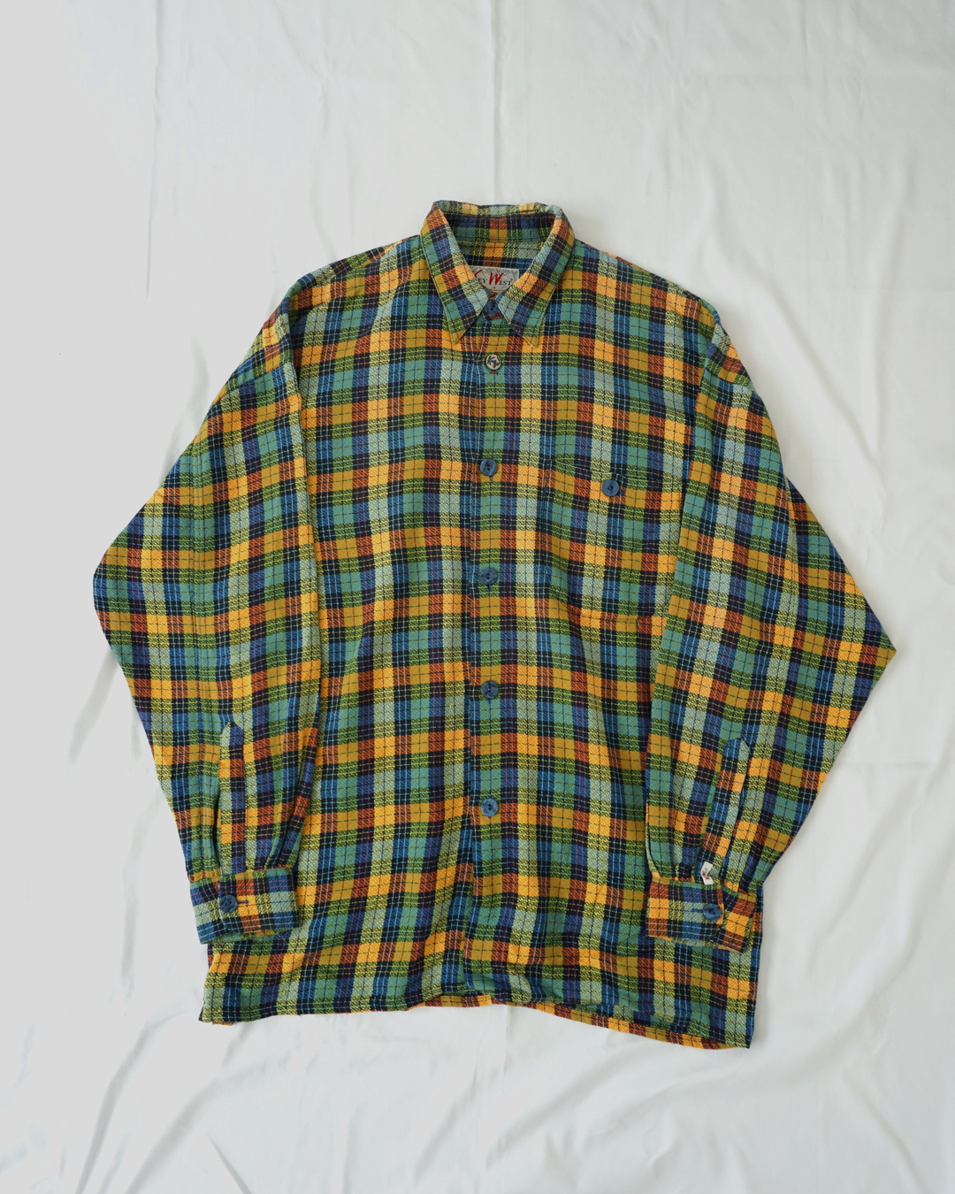 CALCÈLのKey West Shirts製、オレンジ・青・緑・黄の多色チェック柄長袖シャツ。ゆったりとしたシルエットの織り地が特徴。