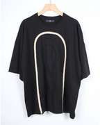 CALCÈLの黒い綿100%天竺Tシャツ。フロントに2種類のコード糸でお地蔵さんのシルエットがデザインされたゆったりとしたシルエットのアイテム。