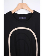 CALCÈLの黒い綿100%天竺Tシャツ。フロントにコード糸で描かれたお地蔵さんのシルエットが特徴的なゆったりとしたデザイン。