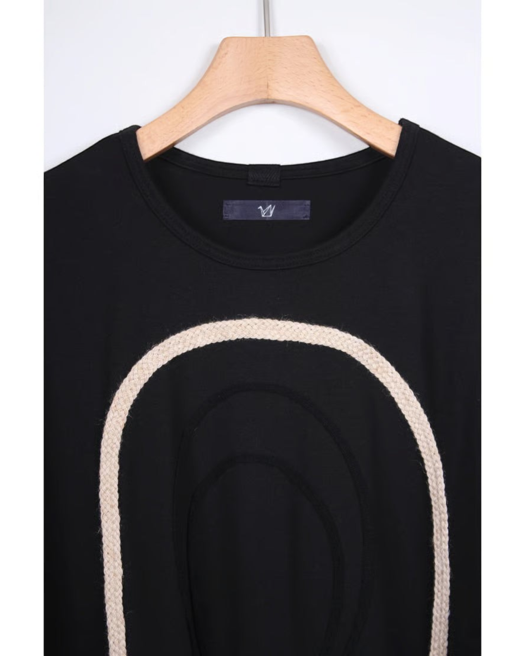 CALCÈLの黒い綿100%天竺Tシャツ。フロントにコード糸で描かれたお地蔵さんのシルエットが特徴的なゆったりとしたデザイン。