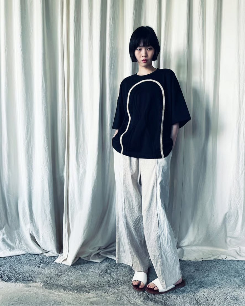 CALCÈLのohta黒色Tシャツ。フロントにコード糸でお地蔵さんのシルエットが描かれた、ゆったりとした綿100%の天竺素材。